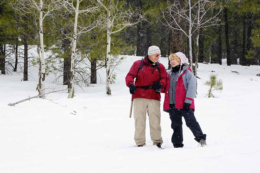 Older couple walking in snow - Functional Medicine in Wasilla, AK | All Seasons Family Health Care